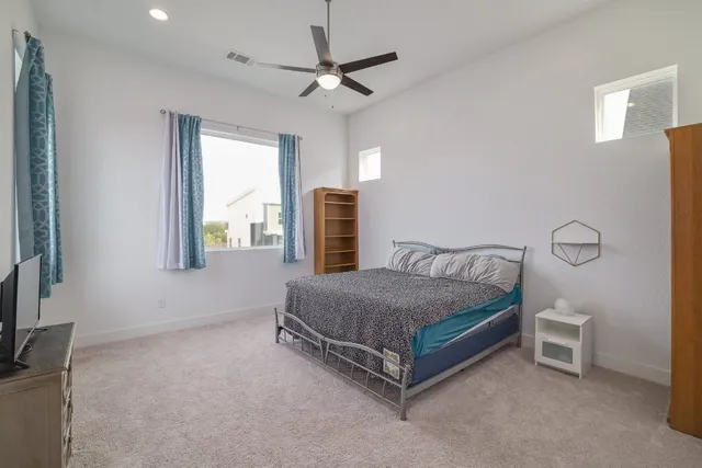 a bed sitting in a spacious bedroom next to a window