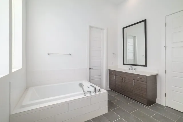 a bathroom with a tub sink and mirror