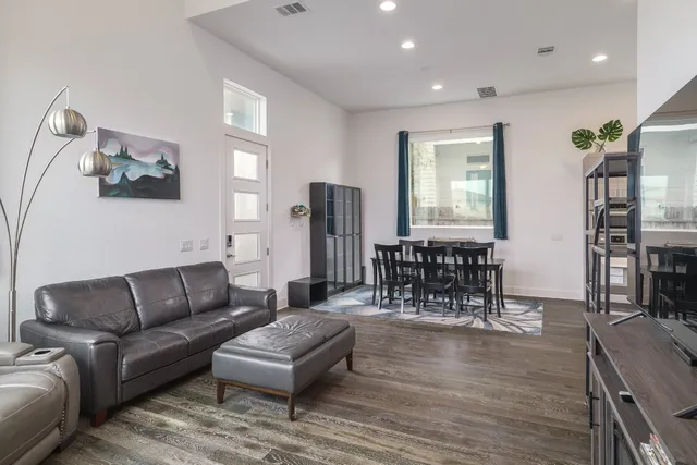 a living room with furniture and a dining table with kitchen view