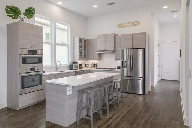 a kitchen with kitchen island a sink appliances a counter space and a window