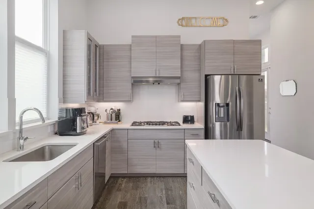 a kitchen with a sink a refrigerator and cabinets