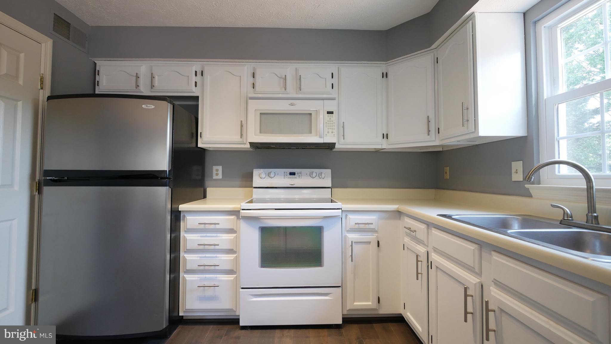 15 Beacon Hill Way Gaithersburg, MD 20878 - Photo 5 of 16 a kitchen with cabinets appliances and a window