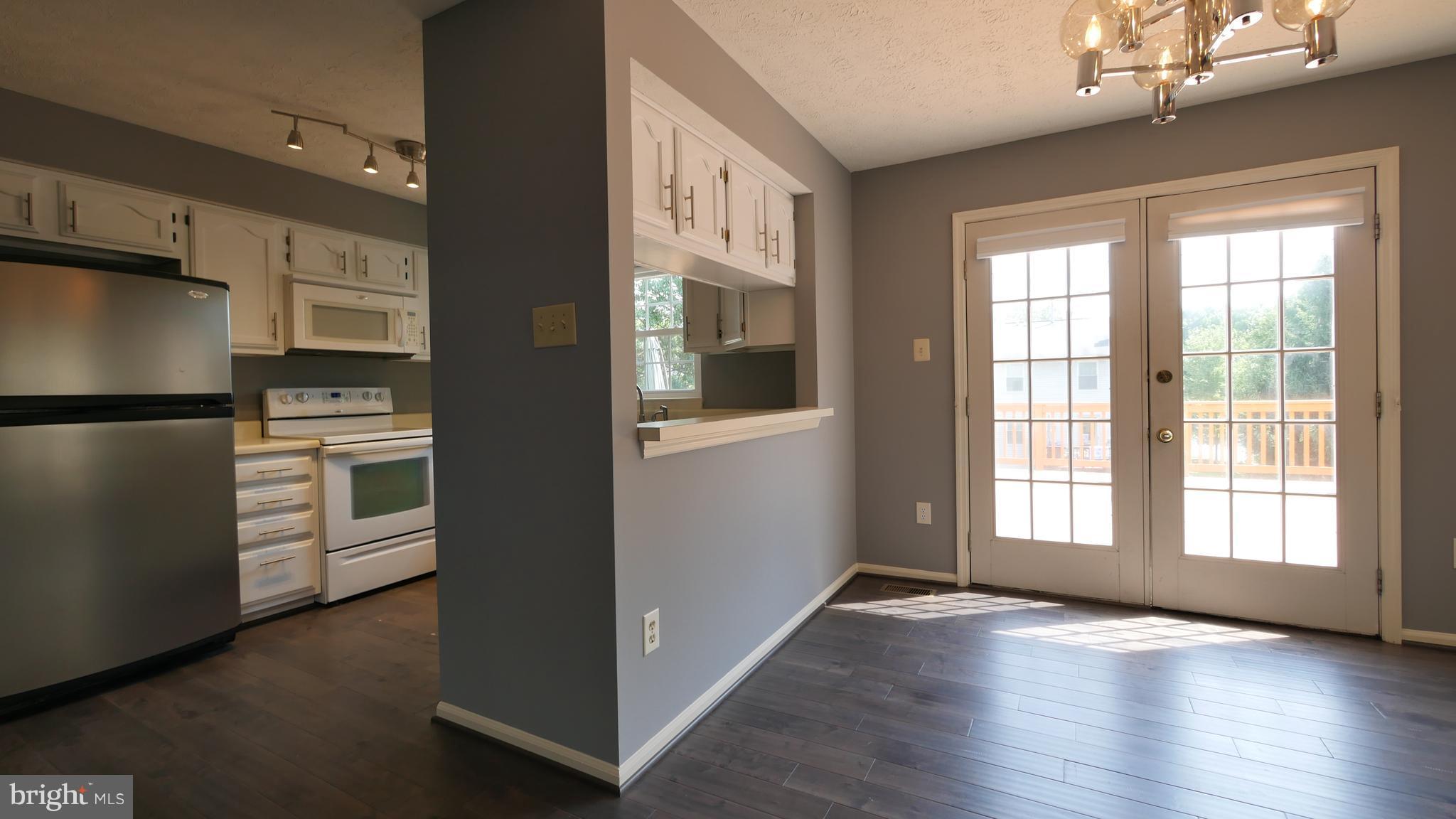 15 Beacon Hill Way Gaithersburg, MD 20878 - Photo 6 of 16 a view of an empty room with a window and wooden floor