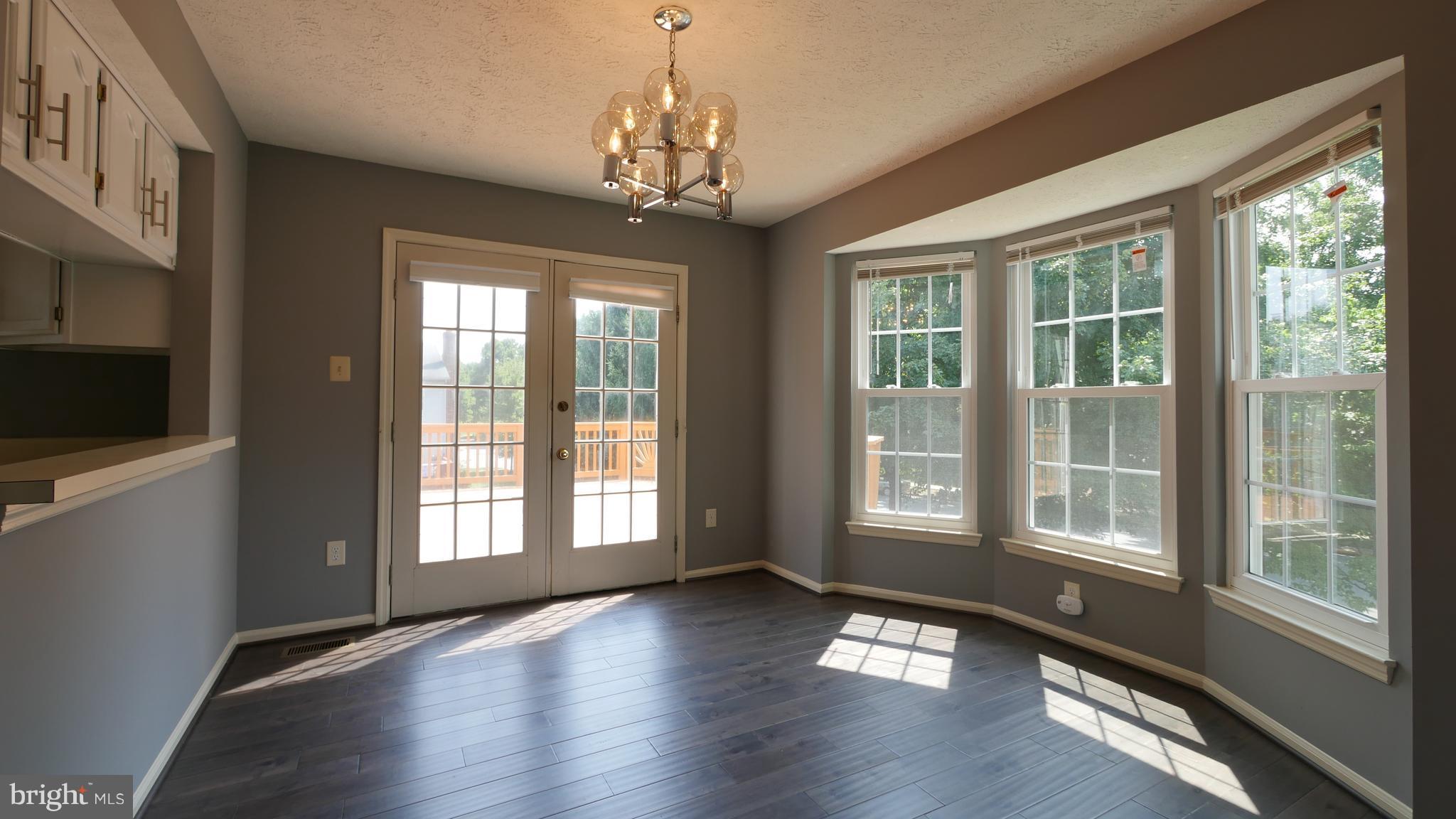15 Beacon Hill Way Gaithersburg, MD 20878 - Photo 7 of 16 a view of an empty room with wooden floor and a window