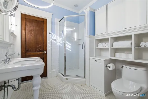 a bathroom with a sink a toilet and shower
