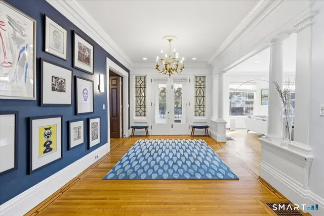 a bedroom with a large bed and a chandelier next to a large window