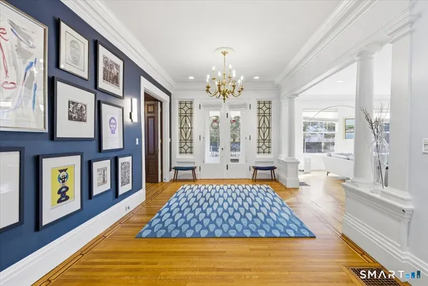 a bedroom with a large bed and a chandelier next to a large window