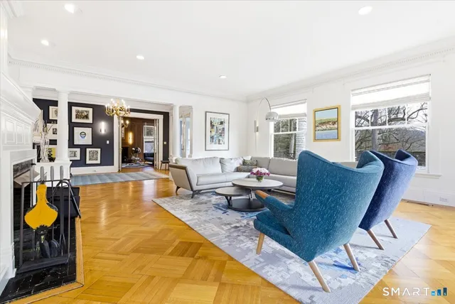 a view of a dining room with furniture a chandelier and wooden floor