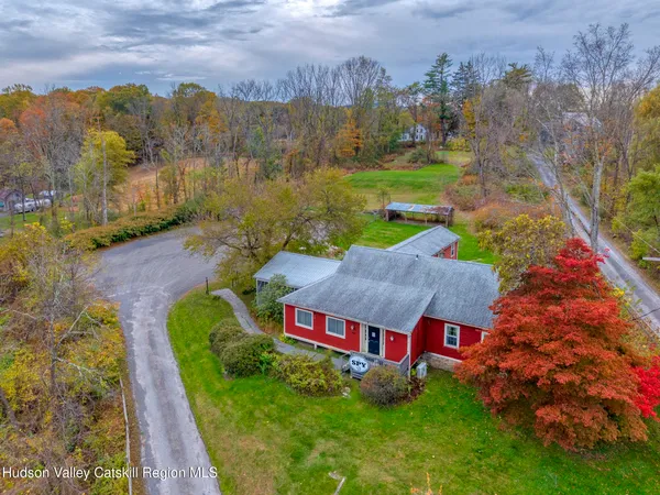 an aerial view of residential houses with outdoor space and trees