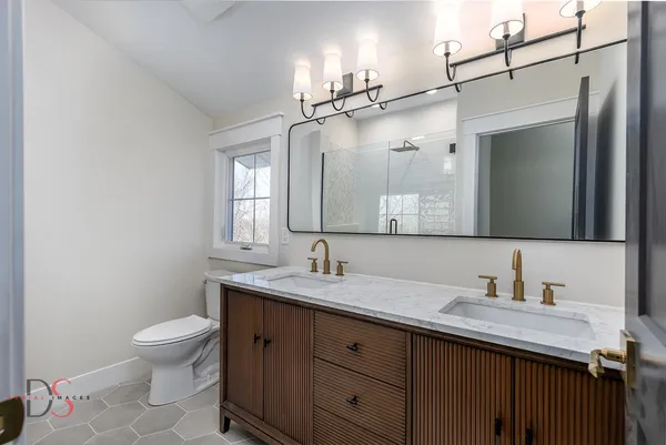 a bathroom with a granite countertop sink toilet a mirror and shower