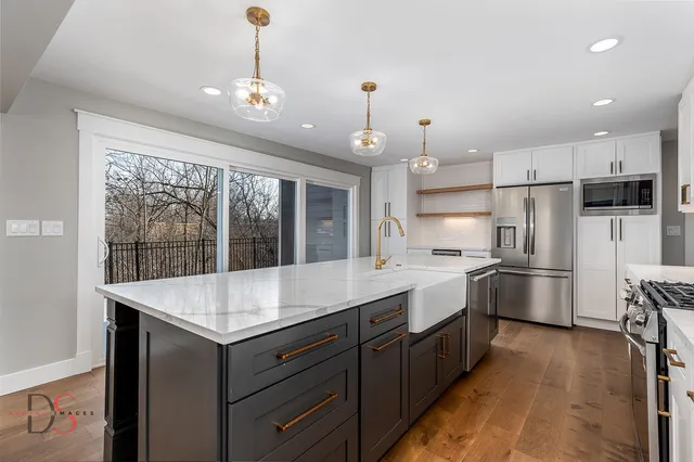 a kitchen with kitchen island white cabinets and refrigerator