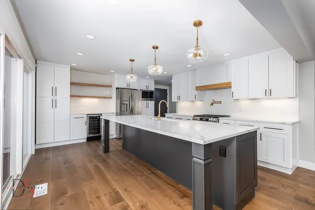 a kitchen with kitchen island a sink stainless steel appliances and cabinets