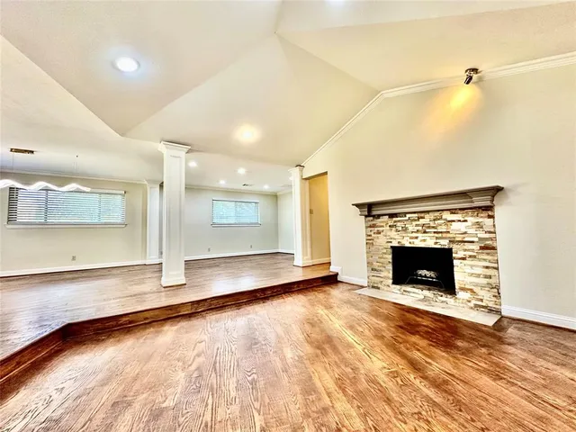 a view of an empty room with a fireplace and a window