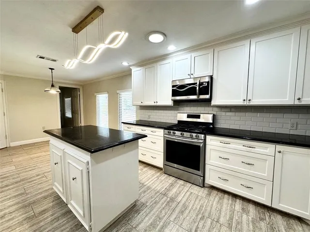 a kitchen with granite countertop a sink and cabinets