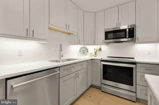 a kitchen with granite countertop white cabinets stainless steel appliances and sink