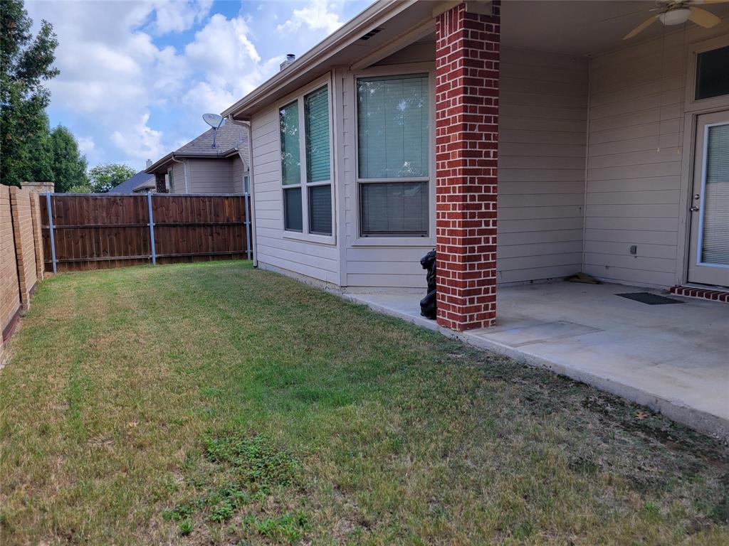a view of a house with a yard and wooden fence