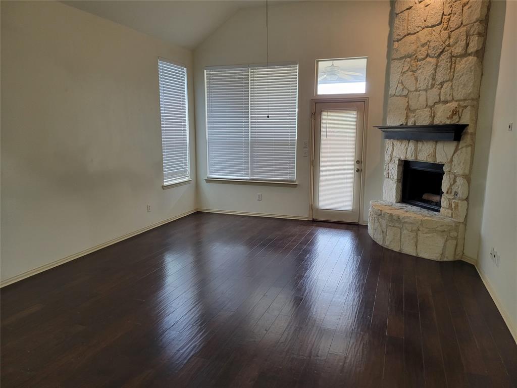 508 Hummingbird Drive Little Elm, TX 75068 - Photo 2 of 14 a view of a livingroom with wooden floor a fireplace and window