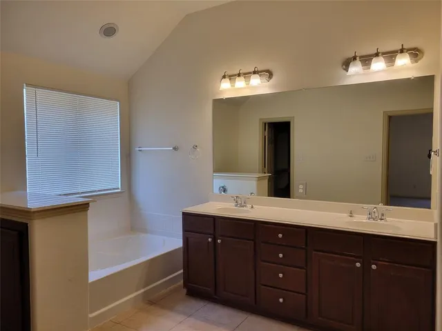 a bathroom with a double vanity sink and a mirror