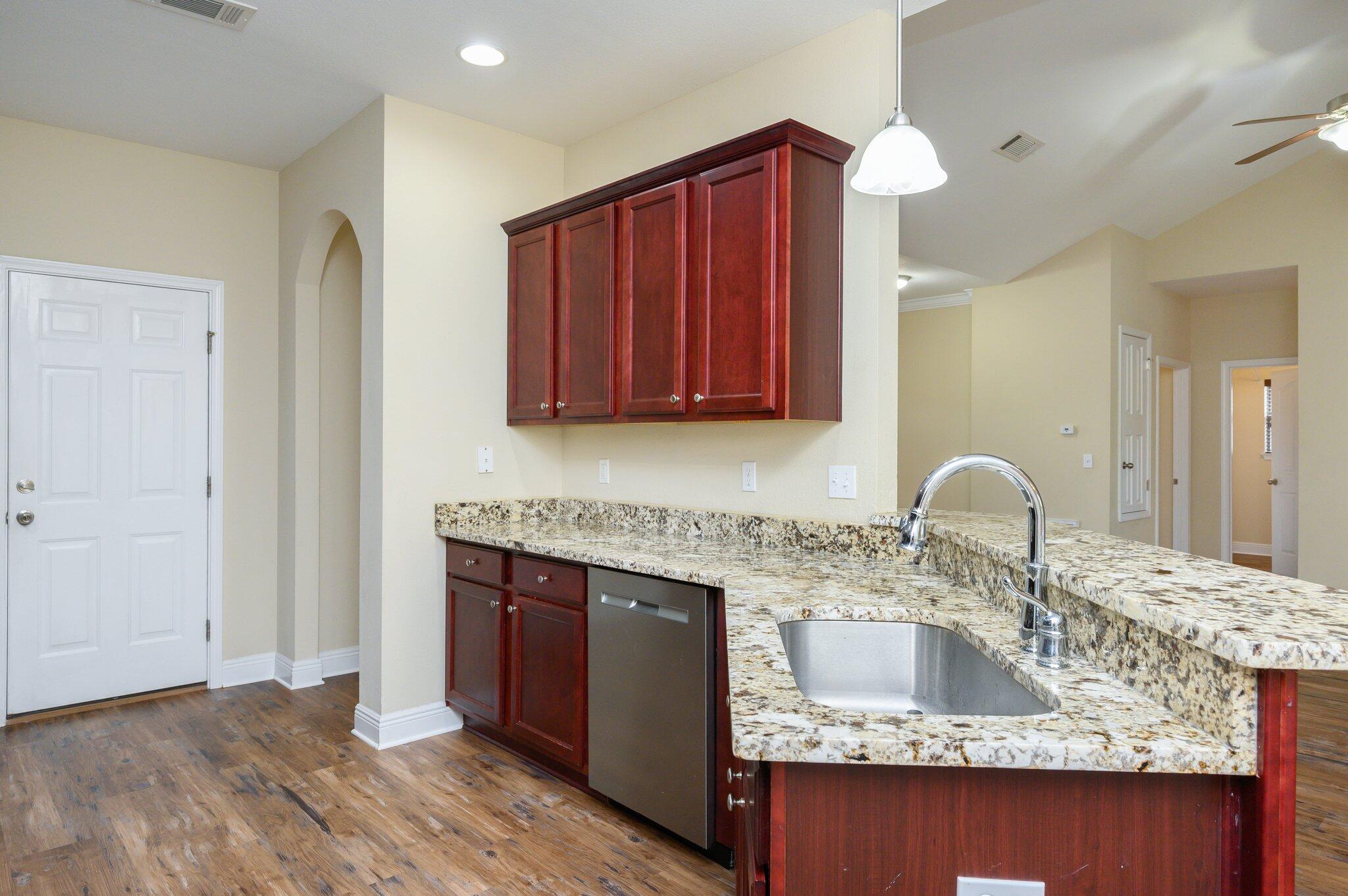 714 Lime Lane Crestview, FL 32536 - Photo 14 of 47 a kitchen with kitchen island granite countertop a sink cabinets and stainless steel appliances