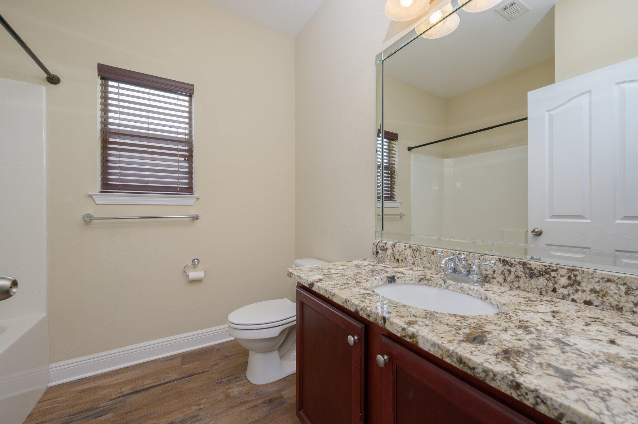 714 Lime Lane Crestview, FL 32536 - Photo 31 of 47 a bathroom with a granite countertop sink toilet and mirror