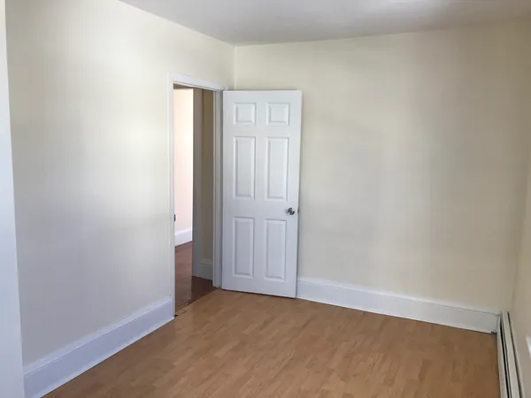 a view of an empty room with closet and a window