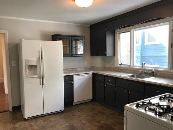 a kitchen with a sink a refrigerator and window
