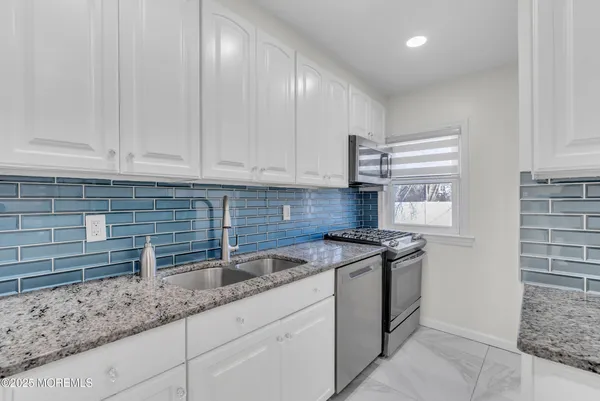 a kitchen with stainless steel appliances granite countertop a sink and a stove