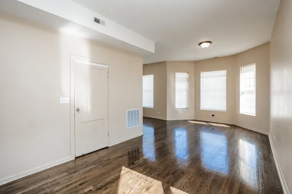 a view of a room with wooden floor and a window