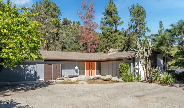 a front view of a house with a tree in front