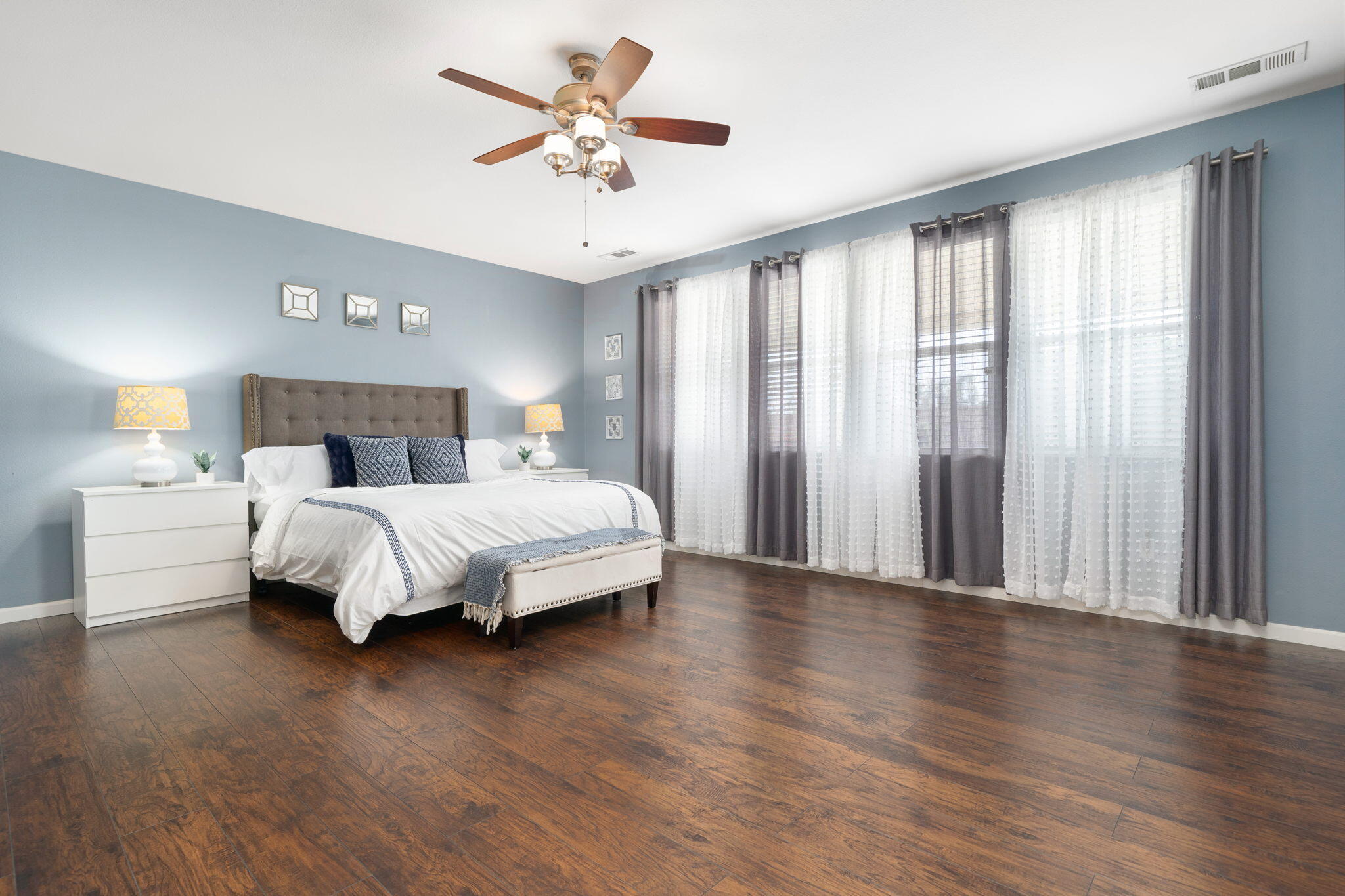 80219 Maramar Drive Indio, CA 92203 - Photo 26 of 41 a bedroom with a large bed and a chandelier