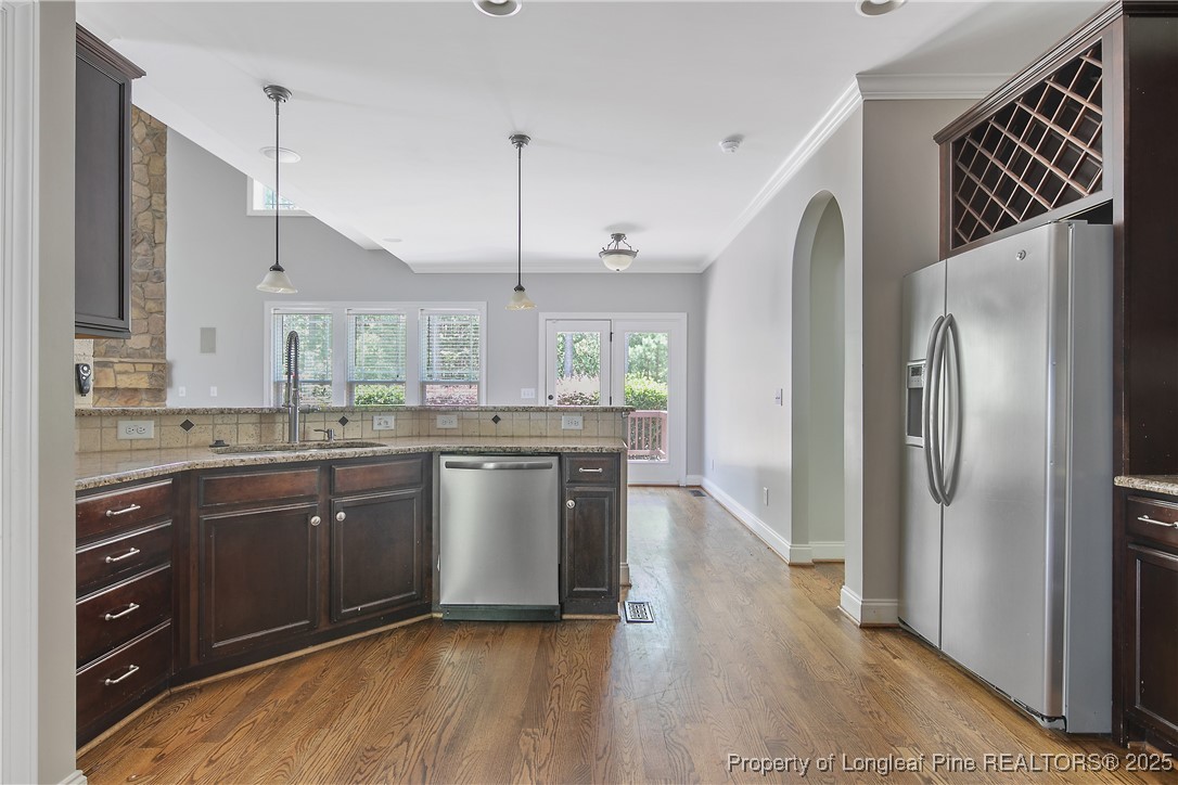 716 Micahs Way North Spring Lake, NC 28390 - Photo 22 of 50 a kitchen with stainless steel appliances granite countertop a refrigerator a sink dishwasher a stove and a wooden cabinets