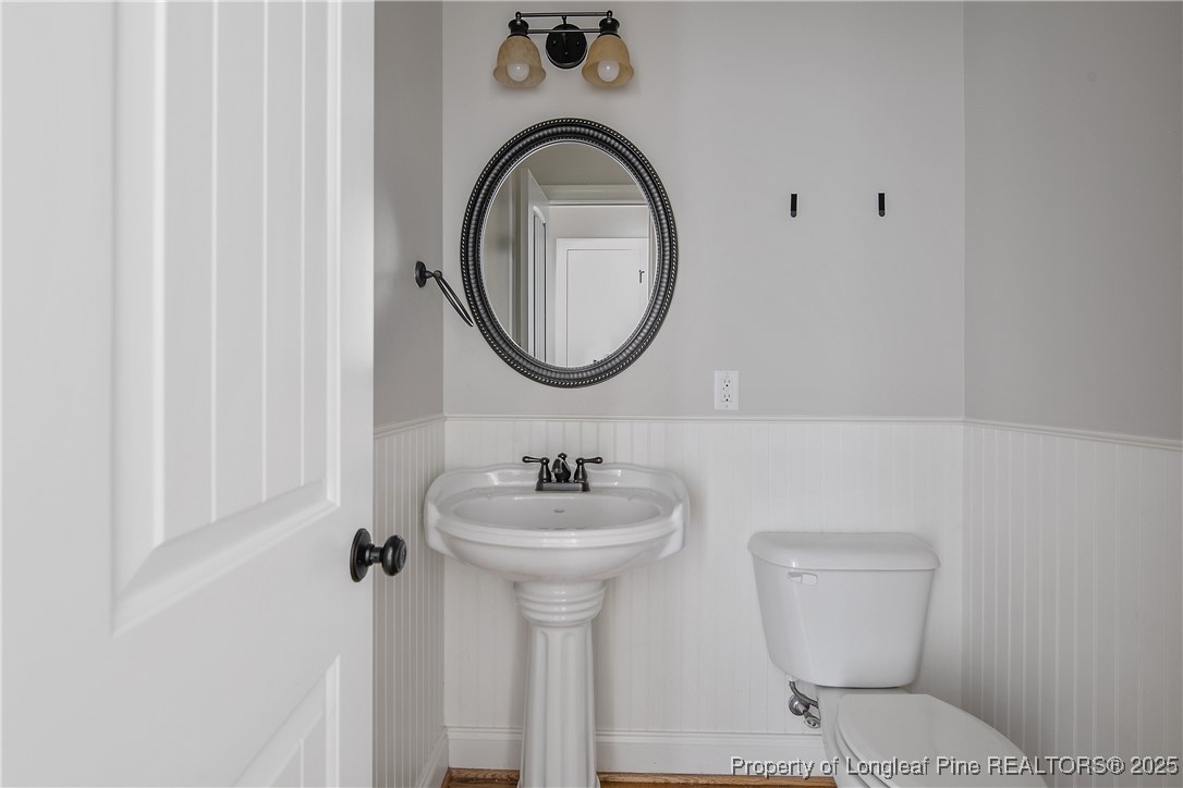 716 Micahs Way North Spring Lake, NC 28390 - Photo 25 of 50 a bathroom with a toilet a sink and mirror