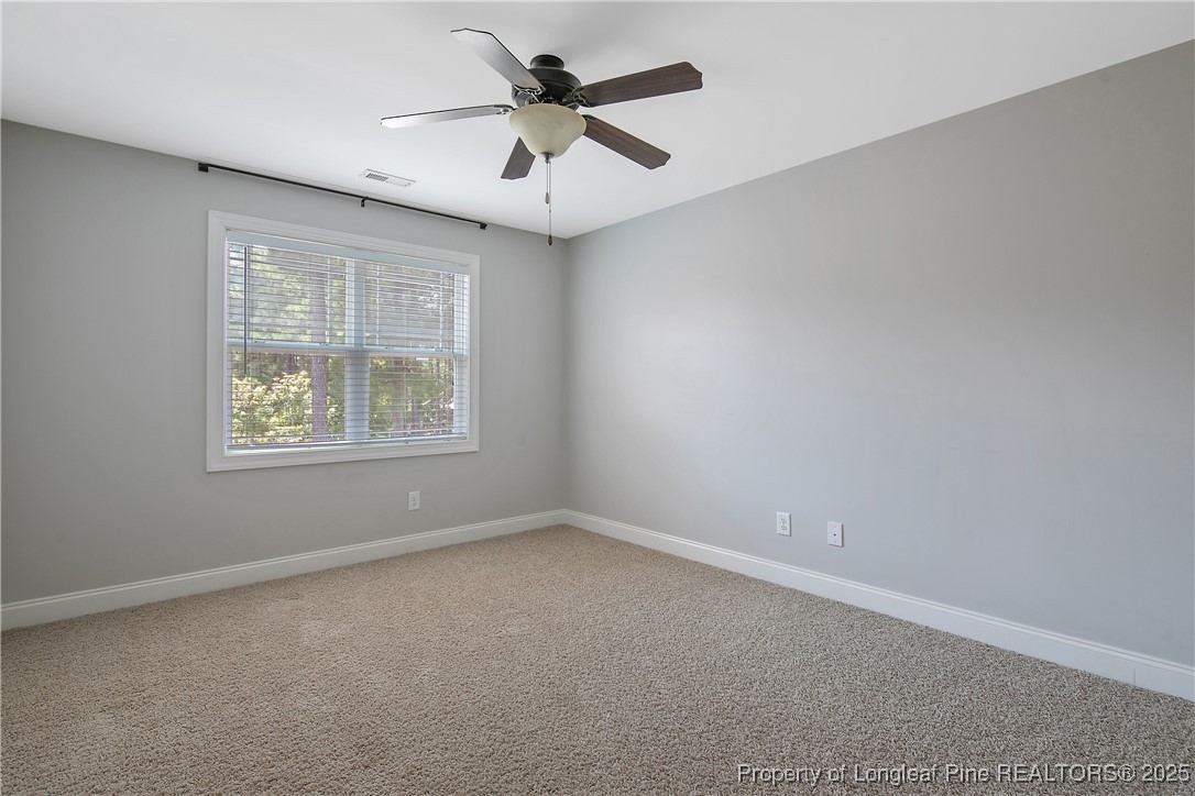 716 Micahs Way North Spring Lake, NC 28390 - Photo 35 of 50 an empty room with a window and a fan