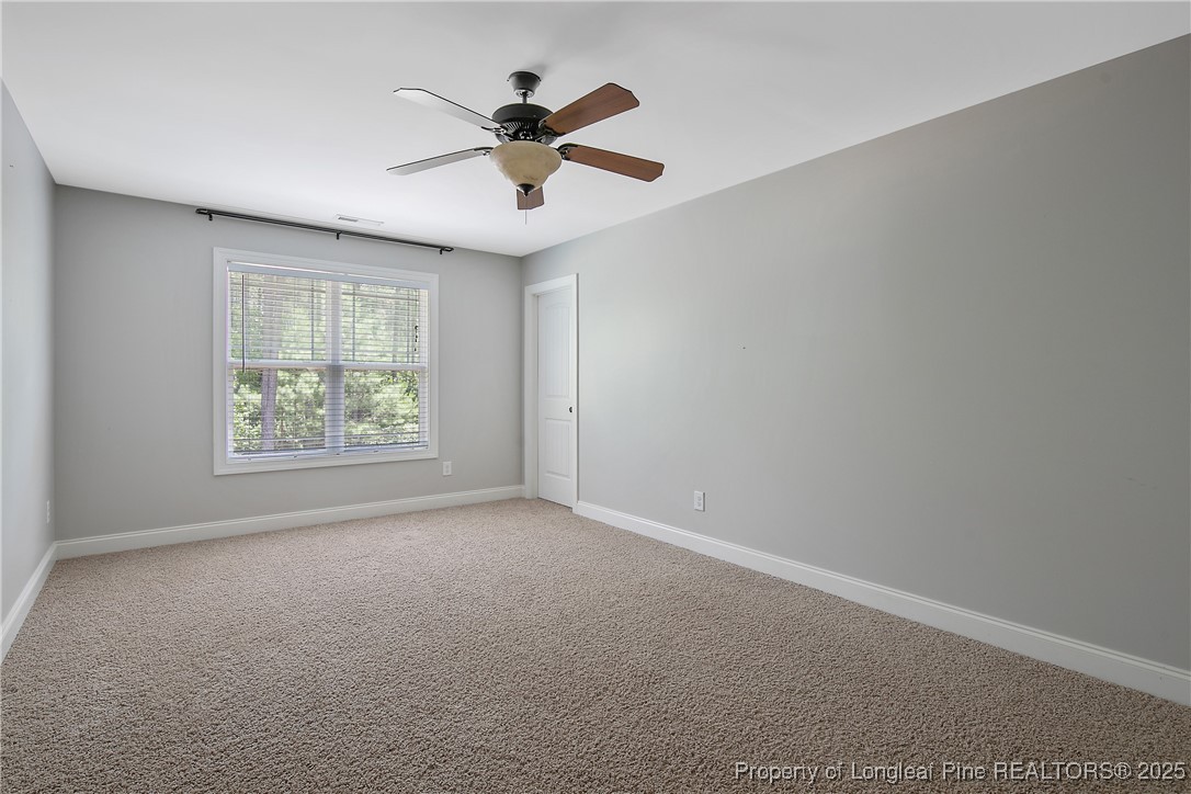 716 Micahs Way North Spring Lake, NC 28390 - Photo 44 of 50 an empty room with ceiling fan and windows