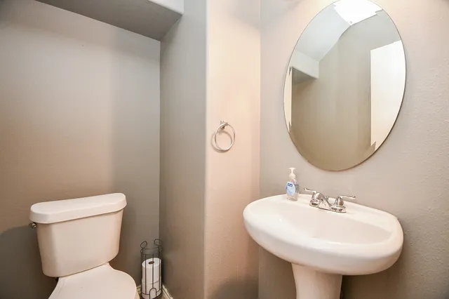 a bathroom with a toilet sink and mirror