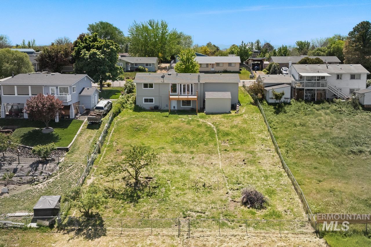 10178 West Fox Ridge Drive Boise, ID 83709 - Photo 31 of 36 Spacious backyard featuring an expansive lawn, mature tree, and a wooden fence defining the property boundary