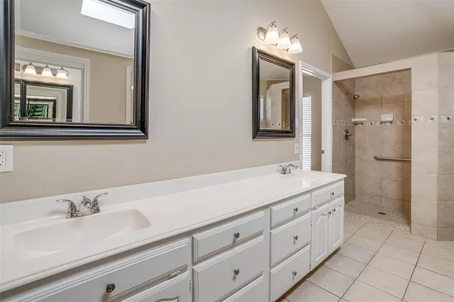a bathroom with a double vanity sink mirror and bathtub