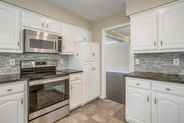 a kitchen with cabinets stainless steel appliances and sink