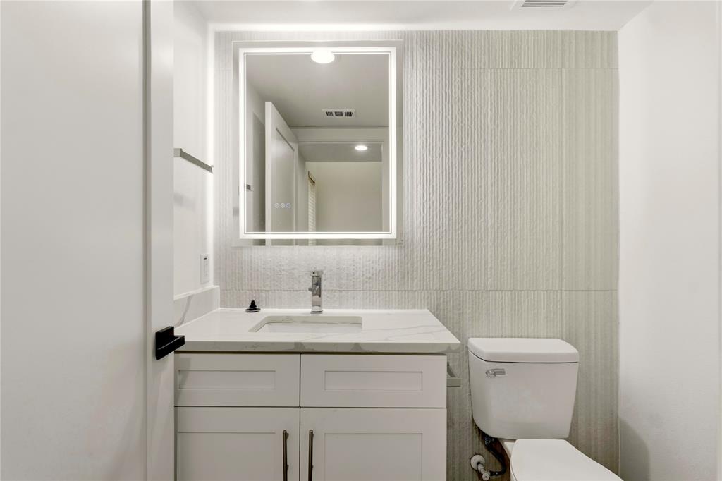 7207 Mohawk Drive, Unit B 3 Dallas, TX 75235 - Photo 11 of 19 a bathroom with a toilet sink vanity and mirror