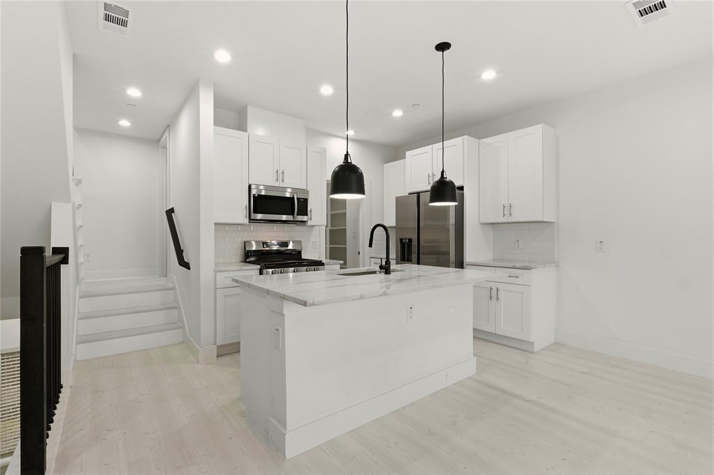 7207 Mohawk Drive, Unit B 3 Dallas, TX 75235 - Photo 7 of 19 a large white kitchen with stainless steel appliances