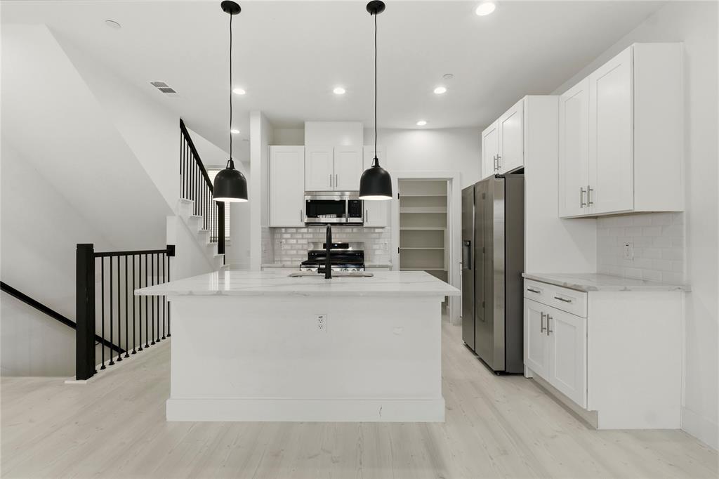 7207 Mohawk Drive, Unit B 3 Dallas, TX 75235 - Photo 8 of 19 a view of kitchen with stainless steel appliances kitchen island refrigerator stove and microwave