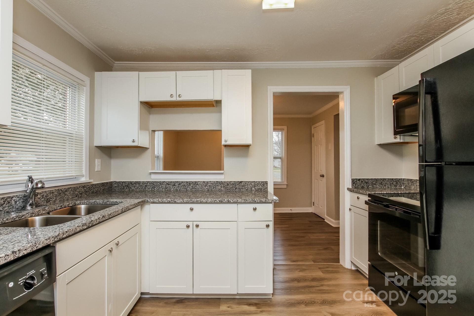 154 Ruffin Loop Troutman, NC 28166 - Photo 8 of 18 a kitchen with granite countertop a sink stove and refrigerator