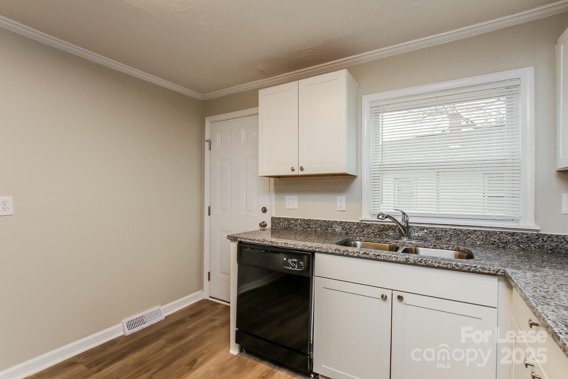 154 Ruffin Loop Troutman, NC 28166 - Photo 9 of 18 a kitchen with granite countertop white cabinets and a sink