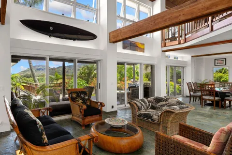 a living room with furniture a fireplace and large windows