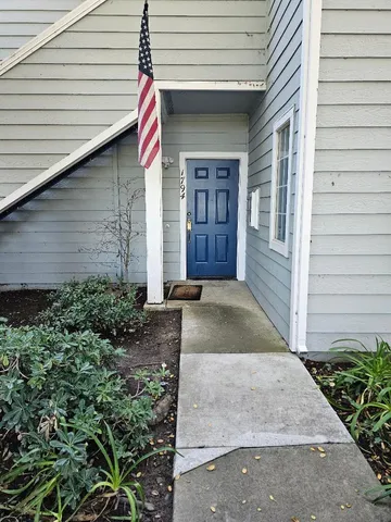 a view of yellow house with potted plants