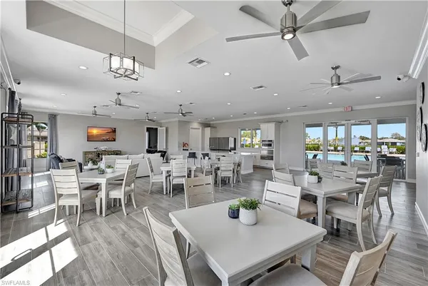 a dining room with furniture a floor to ceiling window and wooden floor