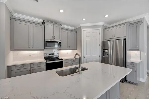 a kitchen with kitchen island a sink stove and refrigerator