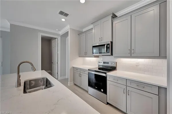 a kitchen with white cabinets and stainless steel appliances