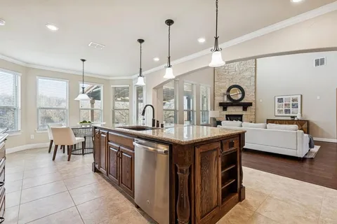 a kitchen with stainless steel appliances granite countertop a sink a stove and a wooden floor