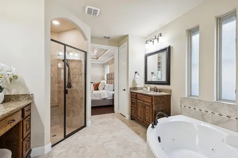 a spacious bathroom with a tub sink and mirror